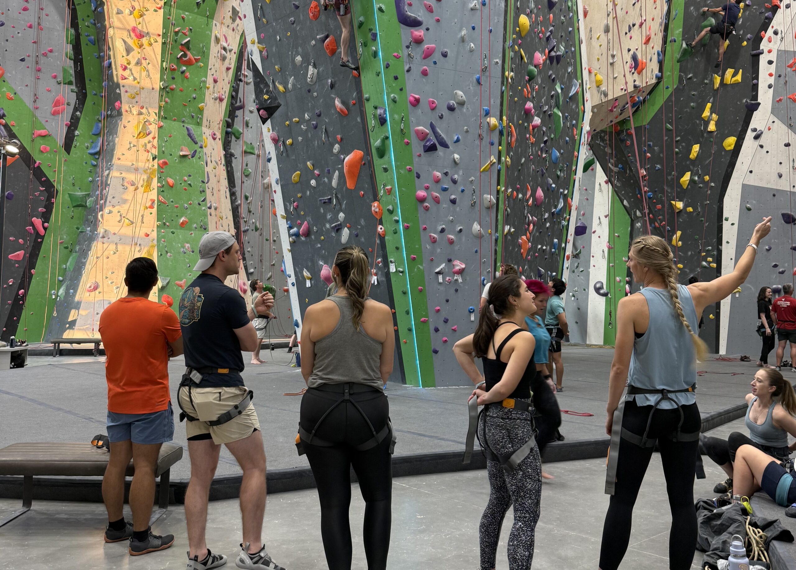 Members sitting together at the base of a climbing wall